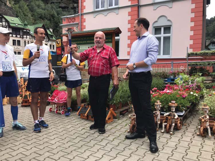 byla pochodeò pøedána u nás ve Høensku, poté opustila Èeskou republiku a vydala se na svou bìžeckou pou do Nìmecka.