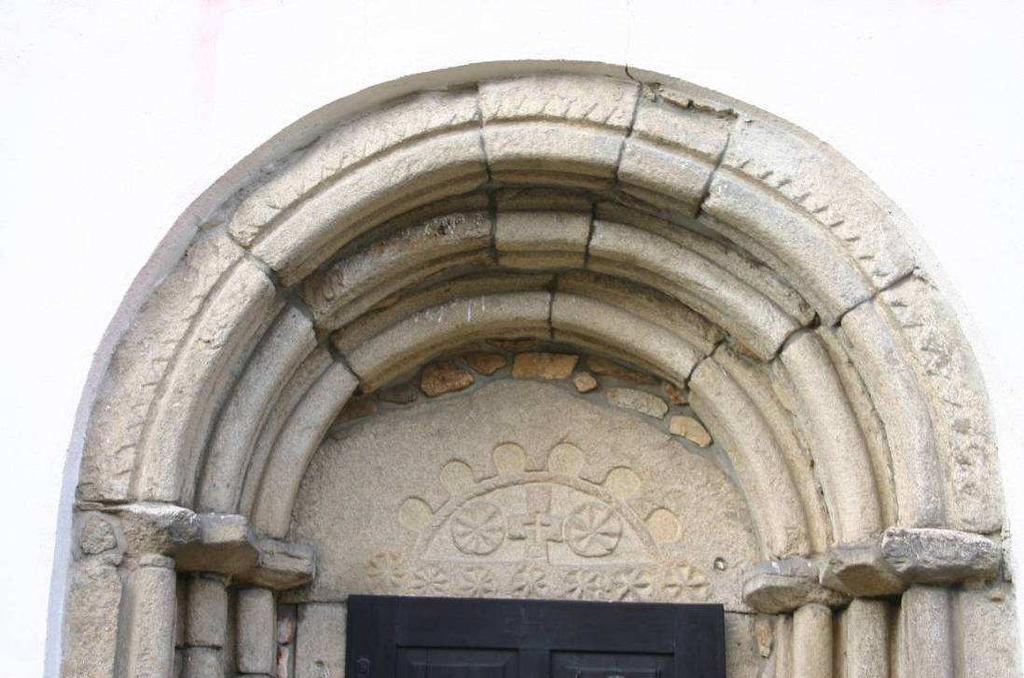 Detail tympanonu vstupního portálu. Foto P. Hejhal, únor 2008. Na tympanonu vstupního portálu je vyobrazen kříž s dvěma rozetami.