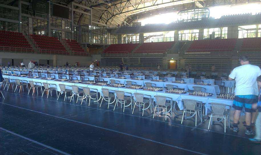 Interiér nové moderní sportovní haly, s připravenými stoly k zahájení šampionátu.