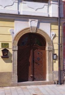 Povrchové úpravy kamene seminář STOP 2017 Obr. 5a, b: Obnažení konstrukčního materiálu znehodnocuje architektonické tvarosloví. Hradec Králové, Malé náměstí čp. 111/4 celek portálu a detail.