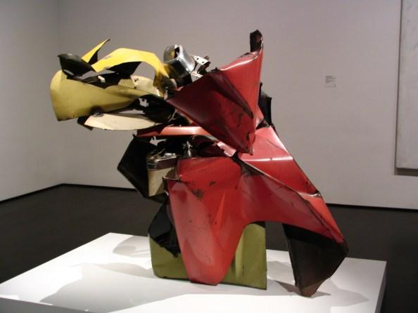42. Chamberlain, J., Žirafa, kol. 1982 1983 Jean Tinguely se ve své tvorbě zabýval i destrukcí svých pohyblivých strojů.