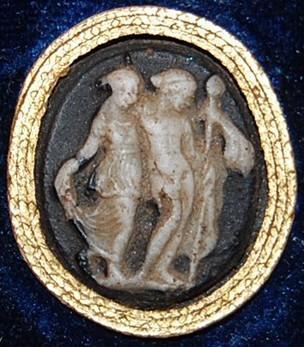 č.: IX/20 Objekt: římská gemma (kamej) Datace: 1.-2. st. n. l. Materiál: sklo, imitace sardonyxu Popis: Nahý mladý Dionýsos s thyrsem v levé ruce má pravou ruku položenou na Ariadnině pravém rameni.