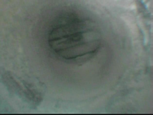 Snímek z endoskopu: Sonda číslo 5 - za kotvou. Zapravená sonda číslo 5. 4.4.3 POLE 3 Podhled nosníků byl bez povrchové úpravy. Spárami mezi nosníky místy zatéká a tvoří se krápníkové výluhy.