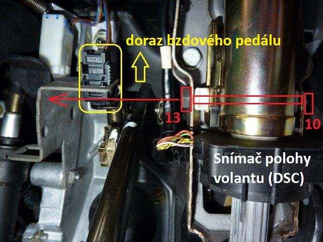 19.) Následující obrázek je z prostoru kolem pedálů, kde se nachází i snímač natočení volantu. Sloupek řízení drží na šroubu, který je znázorněn na obrázku červeně.