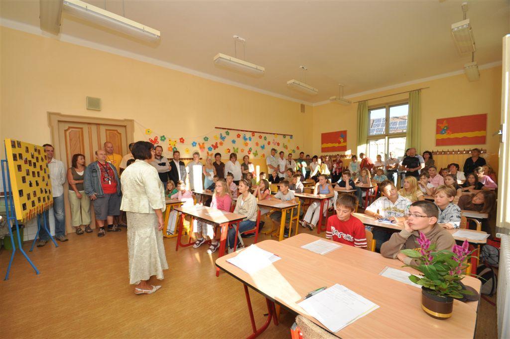 Ve třídě u tabule je veliká nástěnka a na ní fotky a jména všech, se kterými se budu potkávat celých osm let.