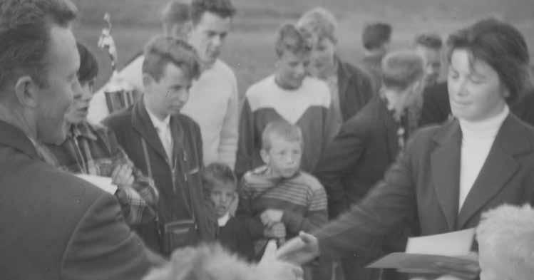 Saga UMSK Ragna Lindberg tekur á móti verðlaunum úr hendi Páls Ólafssonar fyrir besta afrek kvenna í kúluvarpi á héraðsmóti UMSK 1958. Björgvin Guðmundsson og Steinar Ólafsson fylgjast með.