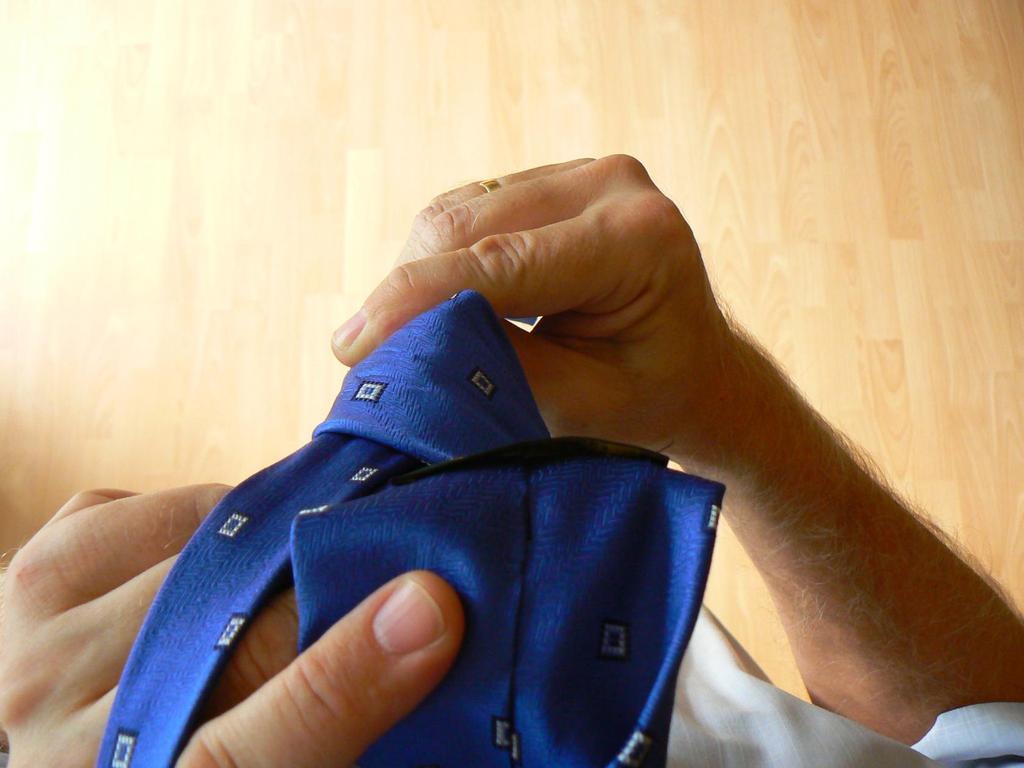 Při protahování je v tomto okamžiku širší konec kravaty převrácen.