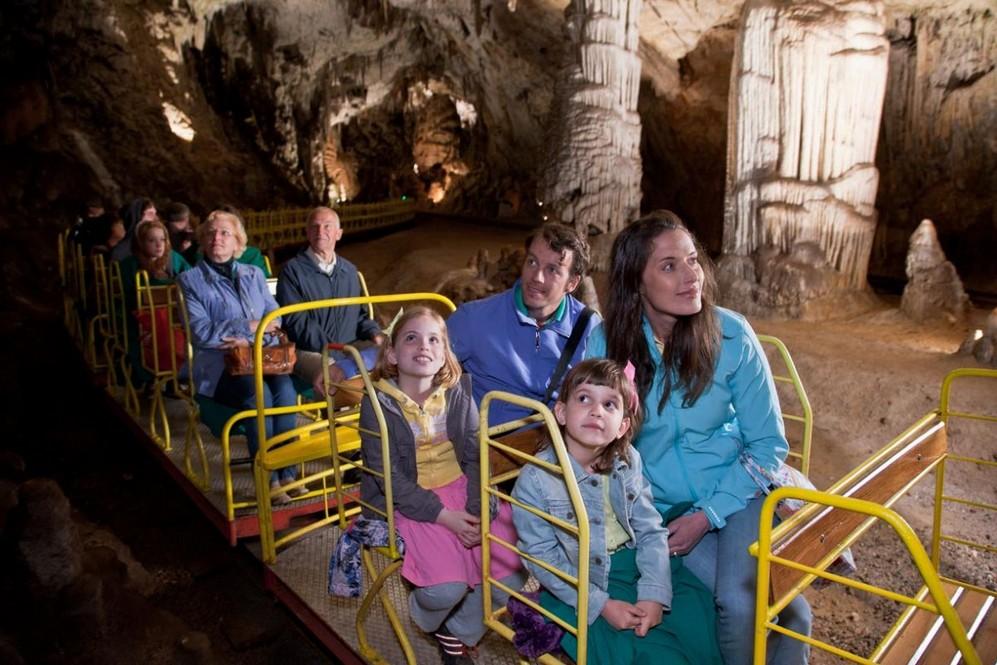 Prohlídka Postojenské jeskyně trvá hodinu a půl, návštěvníci projedou a projdou