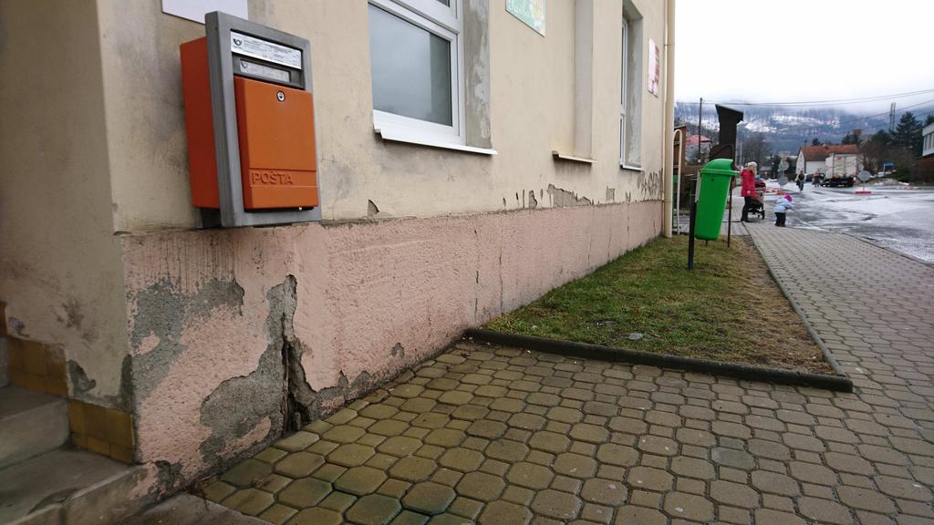 odpadávání narušené omítky u terénu.