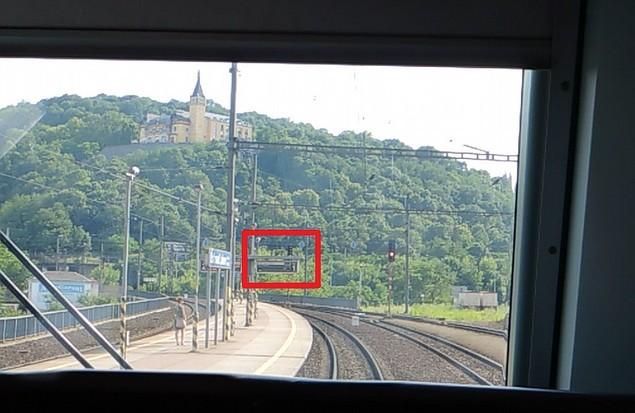 Obr. č. 4: Přístřeškem nástupištních informačních tabulí IZE přerušená viditelnost návěsti Stůj návěstěné cestovým návěstidlem Sc1 (pohled přes čelní okna ze stanoviště strojvedoucího HDV 386.007-9).