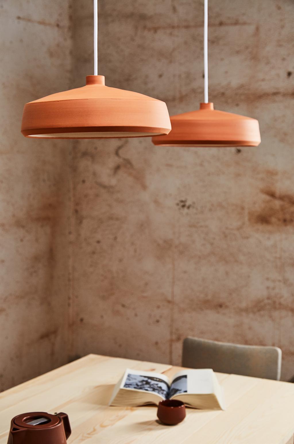 Confeccionadas en terracota, la colección de lámparas de techo Flame tiene una doble personalidad: la superficie exterior de estas lámparas, al natural, ha sido dejada sin barnizar, produciendo un