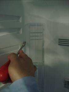 Insert the tip of a flat tip screwdriver to a point close to the upper