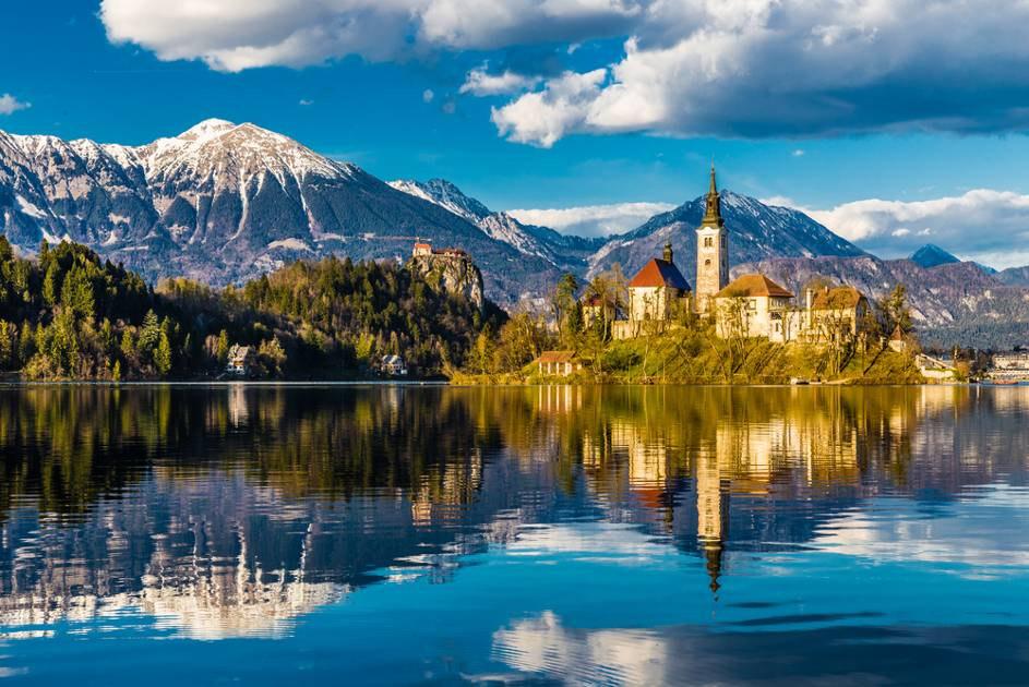 Jezero Bled - symbol Slovinska, nejznám jší pohled. Jezero s poutním kostelíkem Panny Marie na ostr vku, hrad Bled nad vodou.
