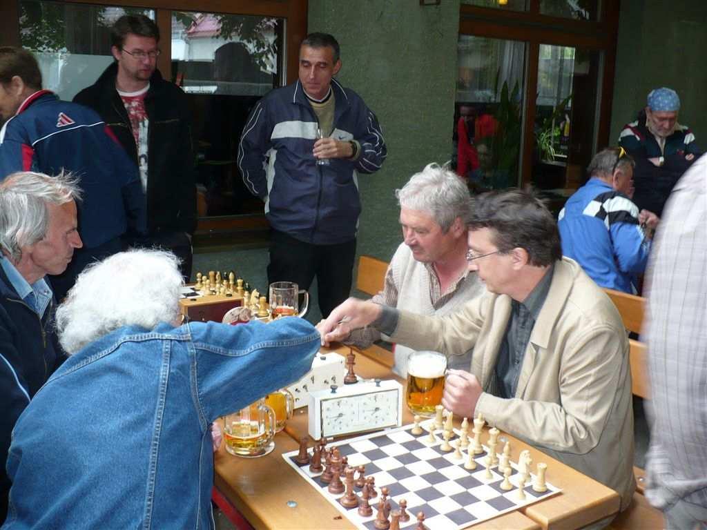 Petrem (s kloboukem) a Daňkem. Do čela celkového pořadí šachové soutěže se při dvou započtených turnajích dostal obhájce trofeje Petr Tr s 36 b před pana Šebestu (34 b) a Laďu Š (32 b).